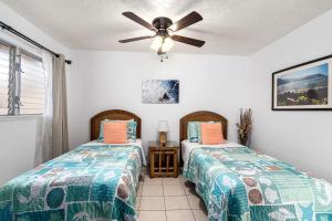 a bedroom with two beds and a ceiling fan at Keauhou Surf & Racquet Townhouse #36 in Kailua-Kona