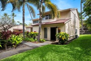a house with palm trees in front of a yard at Keauhou Surf & Racquet Townhouse #36 in Kailua-Kona