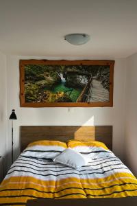 un dipinto appeso a un muro sopra un letto di JT Apartma a Bled