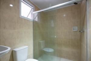 een badkamer met een douche, een toilet en een wastafel bij Hotel Coqueiros in Carapicuíba