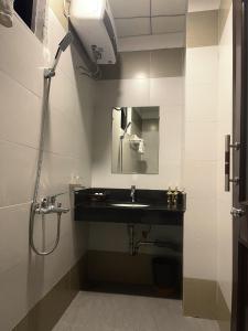 a bathroom with a sink and a shower at Khách sạn HOÀ BÌNH QUẢNG TRỊ in Ðông Hà