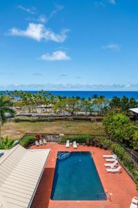 einen Luftblick auf einen Pool mit Liegestühlen und das Meer in der Unterkunft Kahaluu Bay Villas 304 in Kailua-Kona