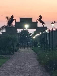 two horses on the top of a building at sunset at Shingwedzi Hotel in Benoni