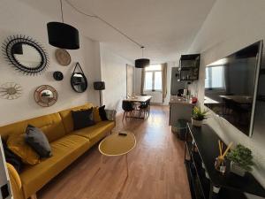 a living room with a yellow couch and a kitchen at 150qm - 5 rooms - free parking - MalliBase Apartments in Hannover