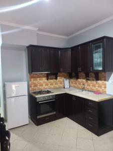 uma cozinha com armários pretos e um frigorífico branco em Studio al' PORTO em Vlorë