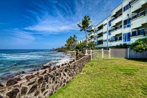 a building on the beach next to the ocean at Banyan Tree 404D in Kailua-Kona