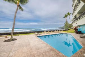 a swimming pool with a view of the ocean at Banyan Tree 404D in Kailua-Kona