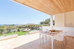 een eetkamer met een tafel en stoelen op een patio bij Sea you soon- Amazing Sea view in Achlia