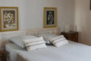 a bedroom with a white bed with two pillows at La Garrigue in Galargues