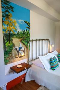 a bedroom with a painting of a man riding a horse at Finca La Manchuria in Salgar