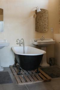 een bad en een wastafel in de badkamer bij La Garrigue in Galargues