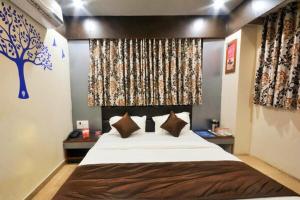 a bedroom with a large bed and a tree mural at Hotel Krishna Naroda in Ahmedabad