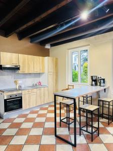 a kitchen with a table and some chairs in it at Au Cosy in Guînes