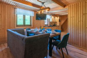 een eetkamer met een tafel en blauwe stoelen bij Apartament GóralSki z widokiem na tatry in Brzegi