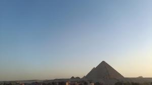 uma vista das pirâmides de Gizé ao pôr-do-sol em fantazia pyramids inn no Cairo