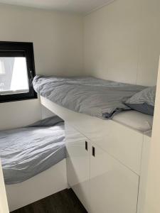 a white bedroom with a bed and a window at EVASION in Nieuwpoort