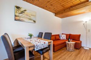 - une salle à manger avec une table et un canapé dans l'établissement Ferienwohnung Metzgerbauernhof, à Wolfach
