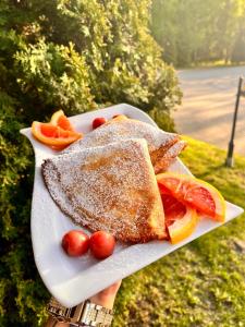 un plato de comida con tostadas y fruta. en Zajazd Biały Młyn, en Sterławki Wielkie