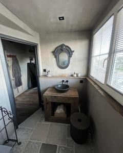 a bathroom with a sink and a mirror on the wall at Bed and Breakfast Lokaal Wadway in Spanbroek