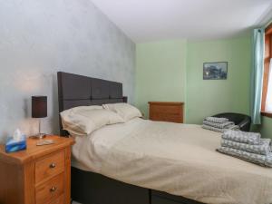 um quarto com uma cama grande e uma mesa de cabeceira em madeira em Thain House em Banff