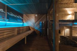 a wooden bench in a room with blue lights at ARIETES MARMONT Apartmány in Tatranska Strba