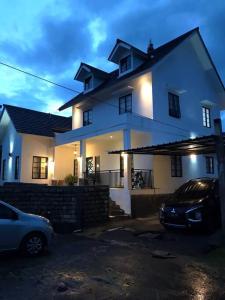 a white house with a car parked in front of it at Stylish Villa at Green Apple U 35A Cipanas Puncak in Sindanglaya