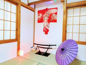 Pokój z fioletowym parasolem i ścianą w obiekcie Masaki 1chome house w mieście Nagoja