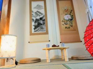 stół w pokoju z obrazami na ścianie w obiekcie Masaki 1chome house w mieście Nagoja
