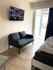 ein Wohnzimmer mit einem Sofa und einem TV an der Wand in der Unterkunft Traumhafte Ferienwohnung - direkter Meerblick - 50m zum Strand in Cuxhaven Duhnen in 1A Lage im Haus Seehütte in Cuxhaven