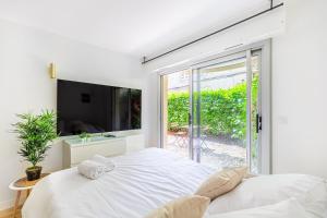 une chambre blanche avec un grand lit et une fenêtre dans l'établissement Lavie Maison Equipped Studio, à Bordeaux