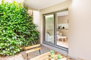 un bâtiment avec un grand mur végétal à côté d'un banc dans l'établissement Lavie Maison Equipped Studio, à Bordeaux