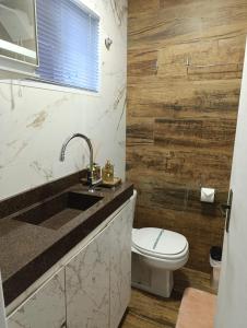 uma casa de banho com um WC branco e um lavatório. em Residencial Luce Del Sole - Casa Nº 5 em Joinville
