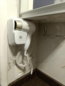 a hair dryer in the corner of a bathroom at Residencial Luce Del Sole - Casa Nº 5 in Joinville