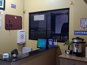 cubículo de oficina con escritorio y ordenador. en Hostal Los Lirios, en Loja