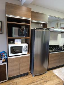 uma cozinha com um frigorífico de aço inoxidável e um micro-ondas em Residencial Luce Del Sole - Casa Nº 5 em Joinville