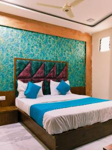 a bedroom with a large bed with blue pillows at Hotel King View in Ahmedabad