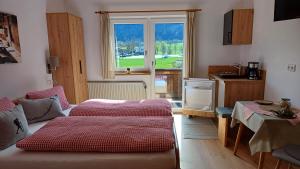 a room with two beds and a kitchen with a window at Haus Barbara in Söll