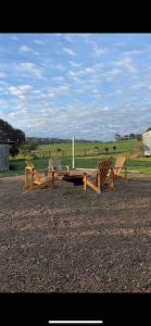 a group of chairs and a picnic table in a field at Rustic Retreat: The Lodge Lurg Sanctuary in Upper Lurg