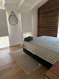 um quarto com uma cama com uma cabeceira em madeira e um espelho em Rustic Retreat: The Lodge Lurg Sanctuary em Upper Lurg