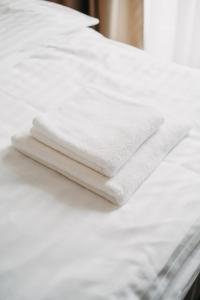 two white towels sitting on top of a white bed at Amenity Penzion Horni Vestonice in Horní Věstonice