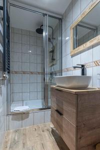La salle de bains est pourvue d'un lavabo et d'une douche. dans l'établissement Apartament GóralSki z widokiem na tatry, à Brzegi
