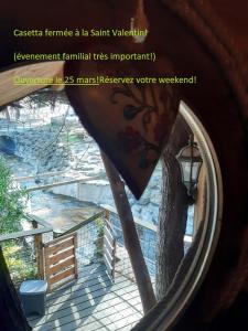 a view from a window of a tree and a fence at La Cabane du Bandit in Pietroso