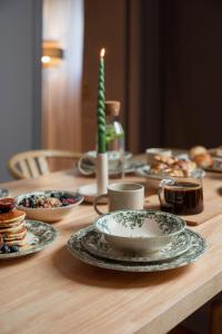 un tavolo in legno con piatti di cibo e una candela di Garden Suites a Roma
