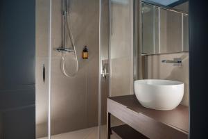 a bathroom with a glass shower with a sink at Garden Suites in Rome