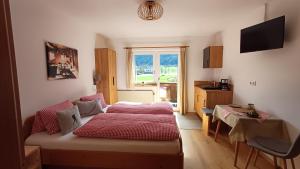 una camera con letto e una cucina con finestra di Haus Barbara a Söll