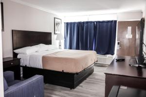 A bed or beds in a room at Riverside Inn and Suites