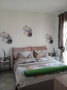 uma cama num quarto com flores na parede em Vivere in famiglia em Orosei