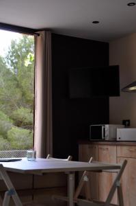 een tafel en stoelen in een kamer met een raam bij Camping Fonts del Algar in Callosa de Ensarriá