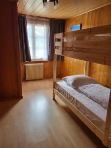 格林德尔瓦尔德Chalet Engi Apt. 3 for up to 8 People的一间卧室，有两张双层床和一扇窗户