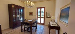 a dining room with a table and chairs and a chandelier at Villa Libertà in Siracusa